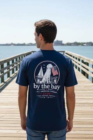 Navy t-shirt with 'by the bay' design and red cap worn by a person, displayed on a mannequin.